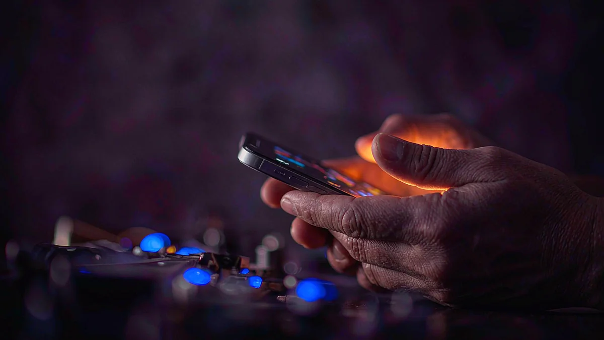 Close-up of hands using a phone above a softly lit desk — L444 guide
